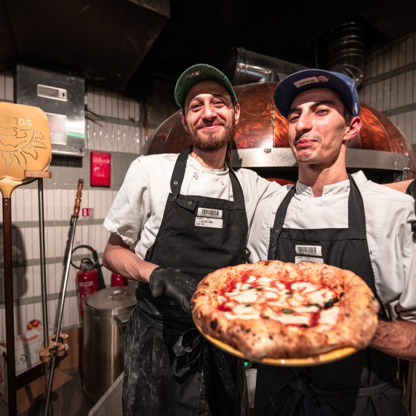 Photo de deux personne souriante avec une pizza a la main